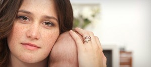 Young white mother with freckles holding a baby