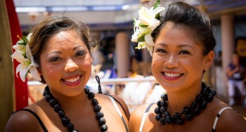 Two women smiling with flowers in their hair