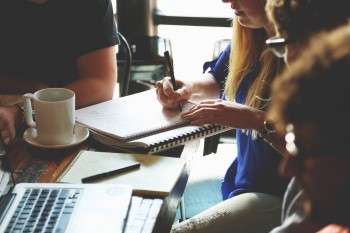 people writing and working with a computer