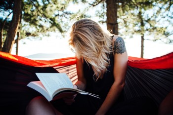 Woman reading a book in a hammock