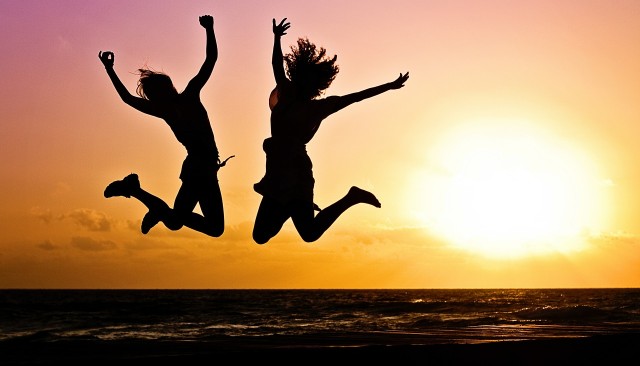 women jumping in the sunset