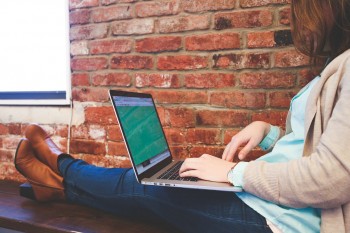 Woman sitting on a bench on her computer