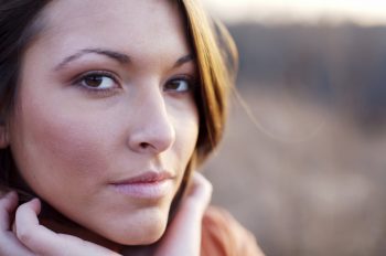 young woman outdoors in field at sunset