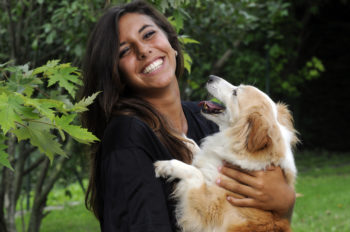 Woman holding her dog and smiling