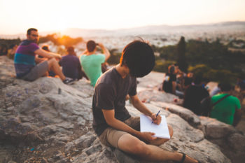 People hiking and boy writing in notebook