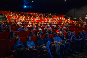 A high contrast photo of individuals sitting in a movie theater